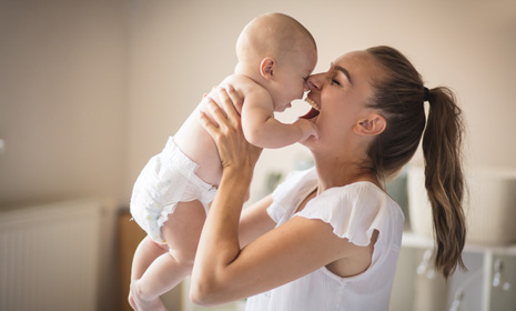 Mother lifting smiling baby