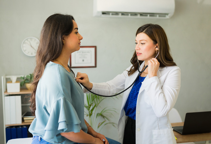 Doctor using stethoscope during patient exam