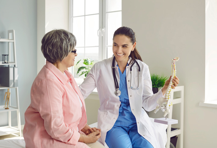 Doctor showing spine model to patient