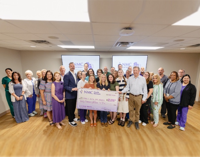 Large group holding ceremonial donation check